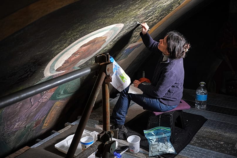 Art conservation technician Celeste Parrendo works on a section of the murals inside  St. Nicholas Croatian Catholic Church in Millvale, United States, 2025.