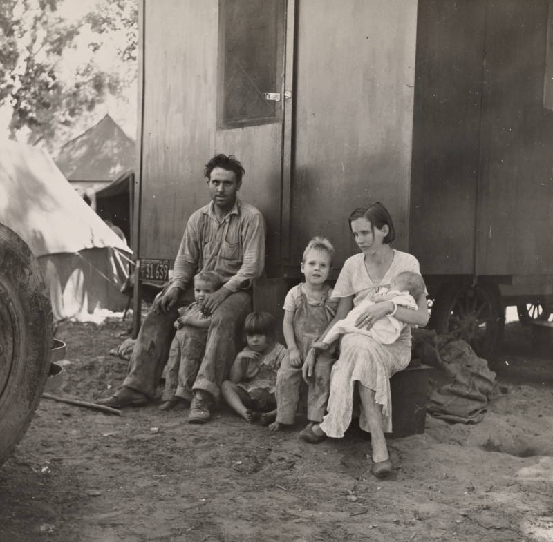 Family Sitting Down Outside