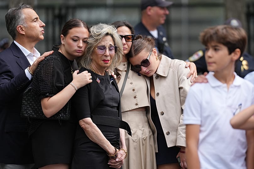 People listen to the U.S. national anthem at the memorial on the 25th anniversary of the September 11, 2001, terrorist attacks, Friday, 11 Sept., 2026, in New York.