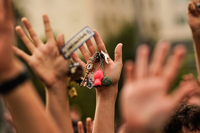 A woman, holding a set of keys in her hand, protests during a housing demonstration.