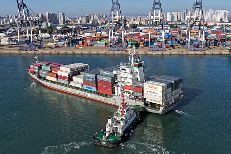 A tugboat pushes a container ship to a port in Yantai, eastern China's Shandong province on Oct. 14, 2026. (Chinatopix via AP)