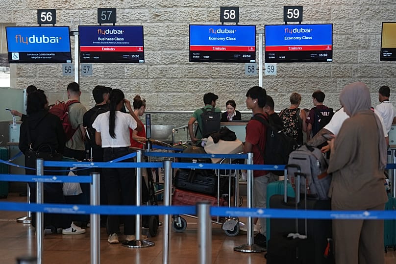 Passengers wait in line at airport