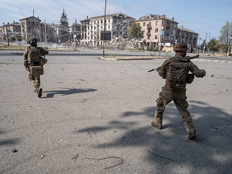Ukrainian servicemen run along a street in Druzhkivka; photo provided by the press service of Ukraine's 93rd Separate Mechanised Brigade